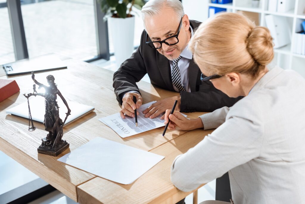 mature serious lawyers discussing contract in office